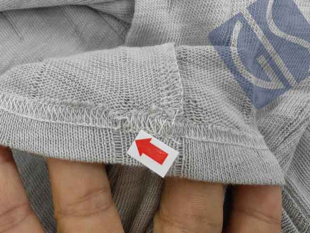 Broken stitch defect on a long-sleeve T-shirt during garment inspection in China