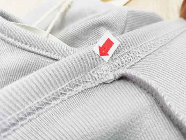 Broken stitch defect on a long-sleeve T-shirt during garment inspection in China